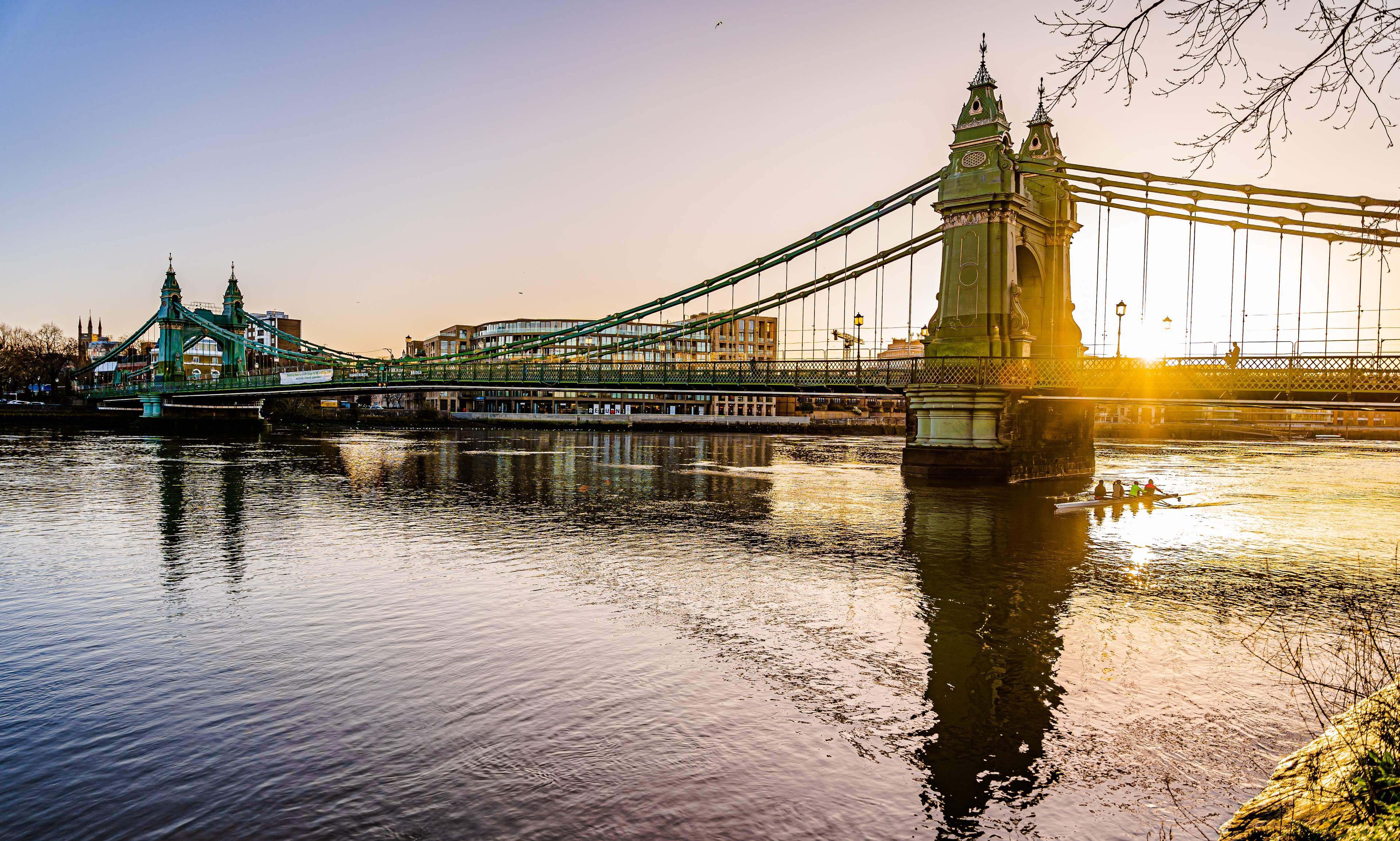 A view from the south riverbank of Thames on Hammersmith Bridge during the golden hour, London, UK